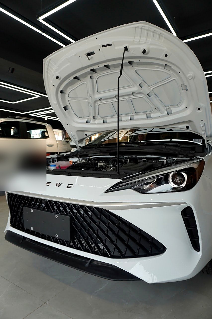 ROEWE i5 con el capó abierto en showroom, motor 1.5L a la vista