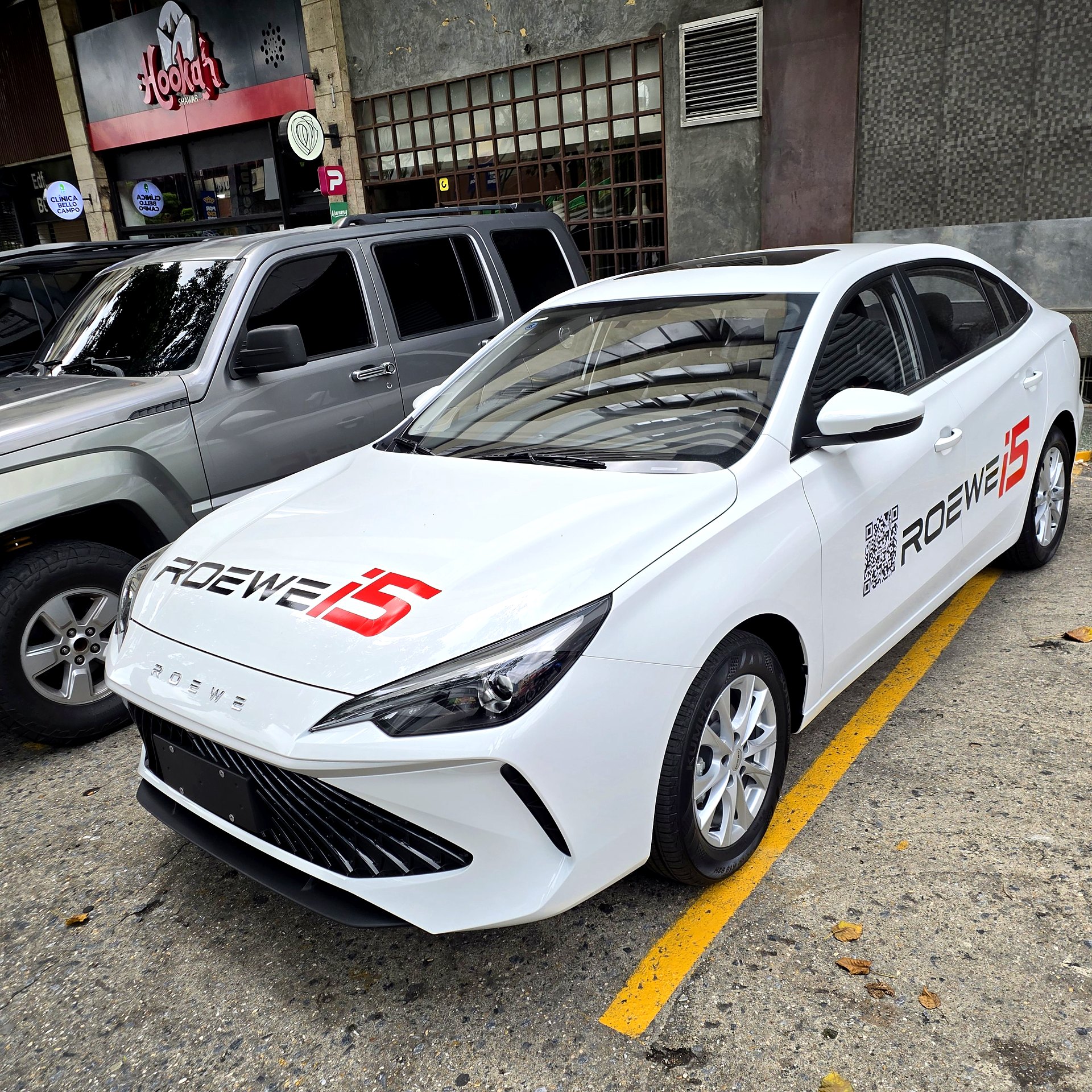 ROEWE i5 2026 blanco estacionado en Caracas, Venezuela, vista frontal tres cuartos con rotulado ROEWE i5